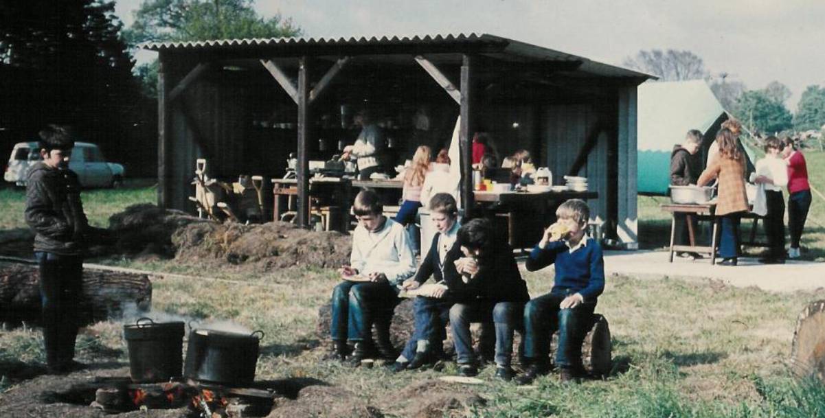 Old grainy image of children in the 70's at a campsite 