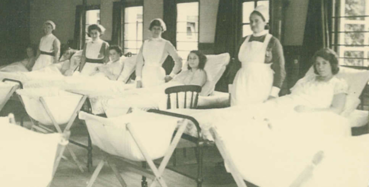 The hive being used as maternity ward with women in hospital beds with old fashion nurses stood behind them