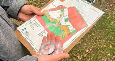 person holding a map of the forest and a compass