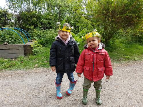 2 children with homemade crowns with leaves stuck on